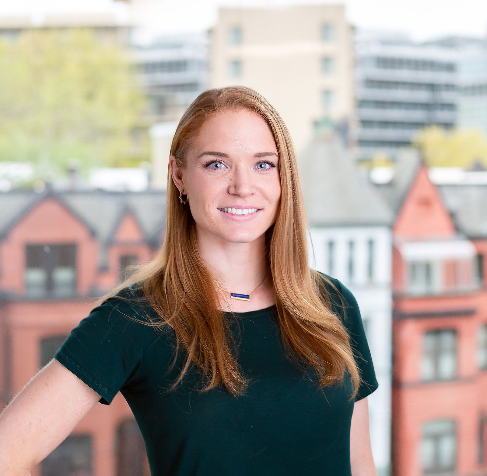 Professional corporate headshot - redhead cityscape backdrop
