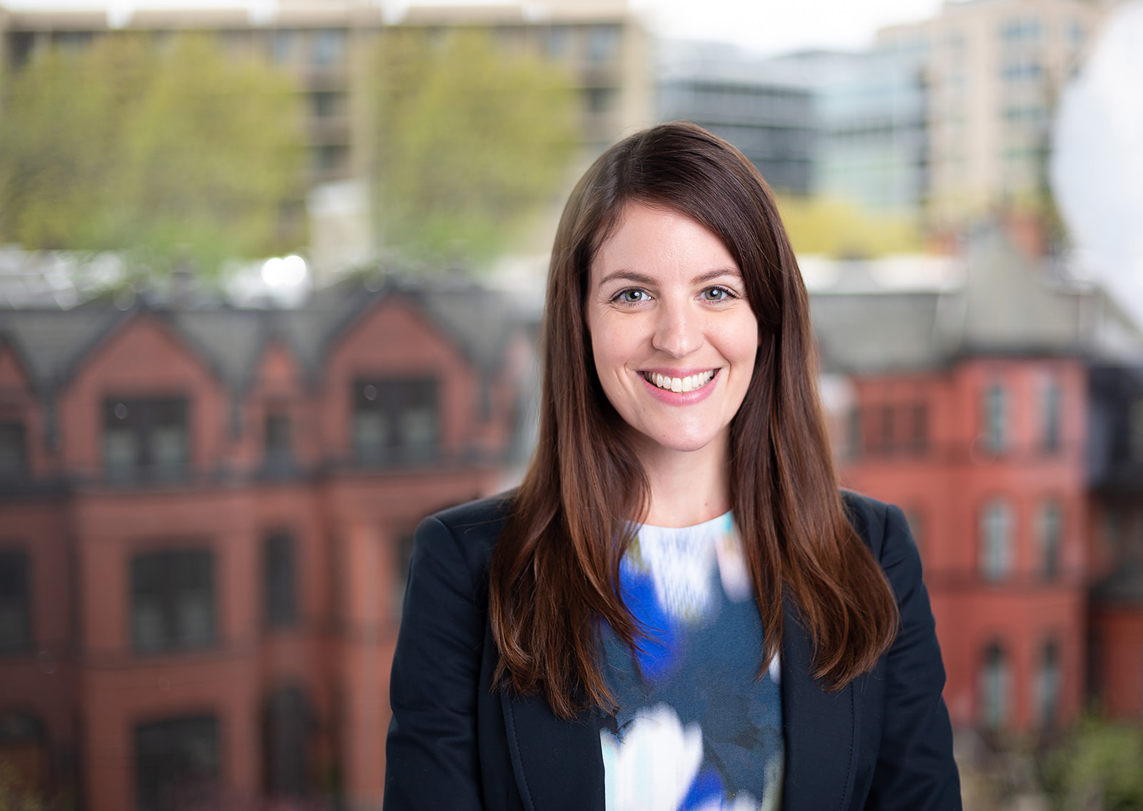 Professional corporate headshot - brunette cityscape backdrop