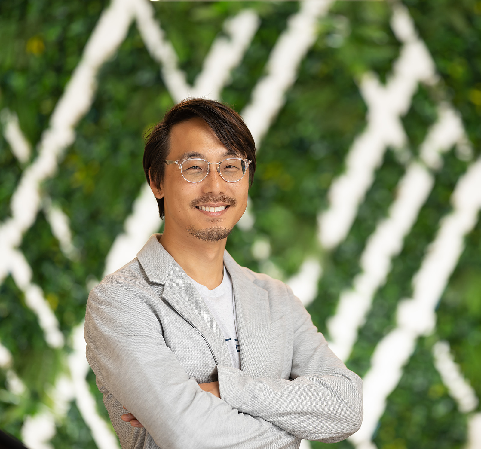 FedTech team portrait - man with glasses green wall backdrop