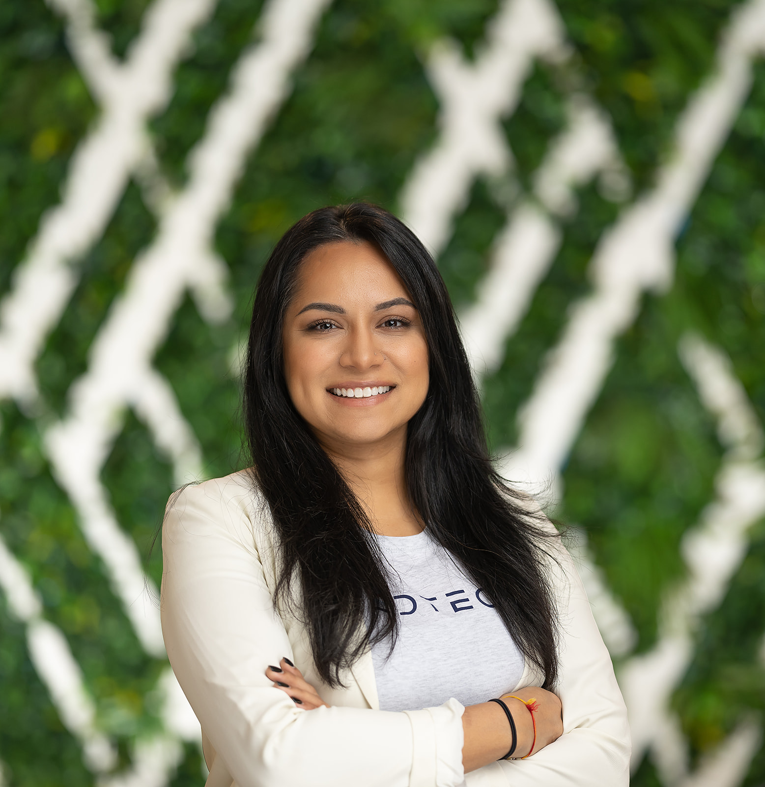 FedTech team portrait - woman in blazer green wall backdrop